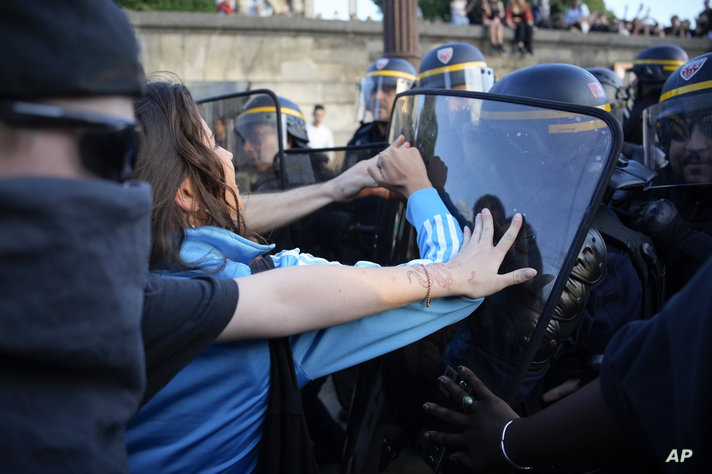 Police officers face protesters on Concorde square during a protest in Paris, France, Friday, June 30, 2023. French President…