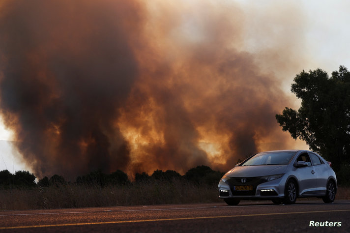 Smoke rises from a fire close to the area where, according to Israel's emergency services, a rocket was fired from Lebanon which killed a man when it landed in a kibbutz, in Horshat Tal
