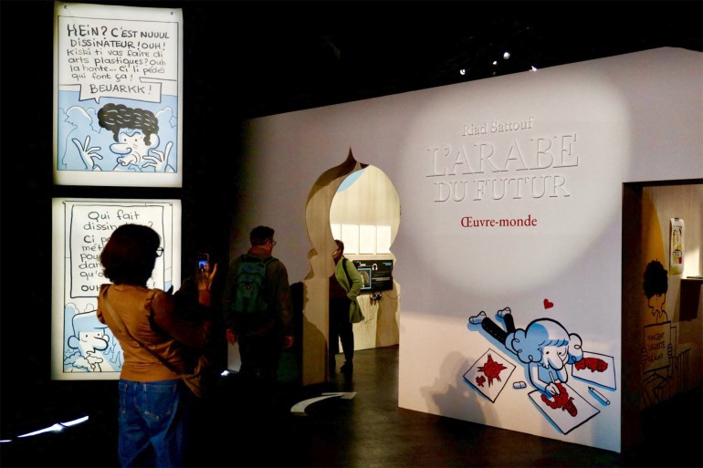 Visitors look at creations on display at the Riad Sattouf exhibition at Vaisseau Moebius during the 51st Angouleme International Comics Festival in Angouleme, western France, on January 24, 2024. (Photo by YOHAN BONNET / AFP)