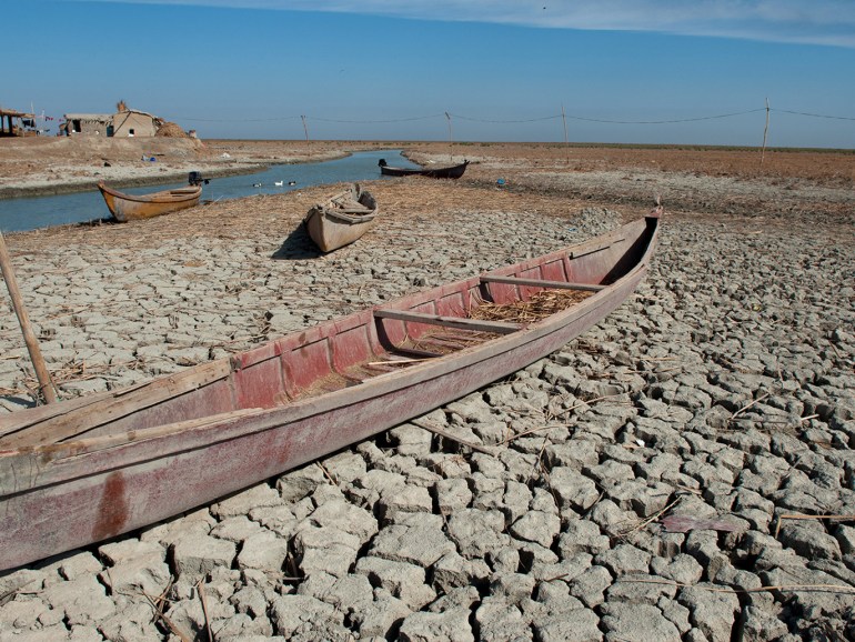 AL-CHIBAYISH, MARSHES OF SOUTHERN IRAQ, IRAQ - 2018/11/01: A traditional Marsh Arab boat seen laying idle on dry and cracked Marsh in the Central Marshes of Southern Iraq. Climate change, dam building in Turkey and internal water mismanagement are the main causes of a severe drought in the southern wetlands of Iraq. (Photo by John Wreford/SOPA Images/LightRocket via Getty Images)