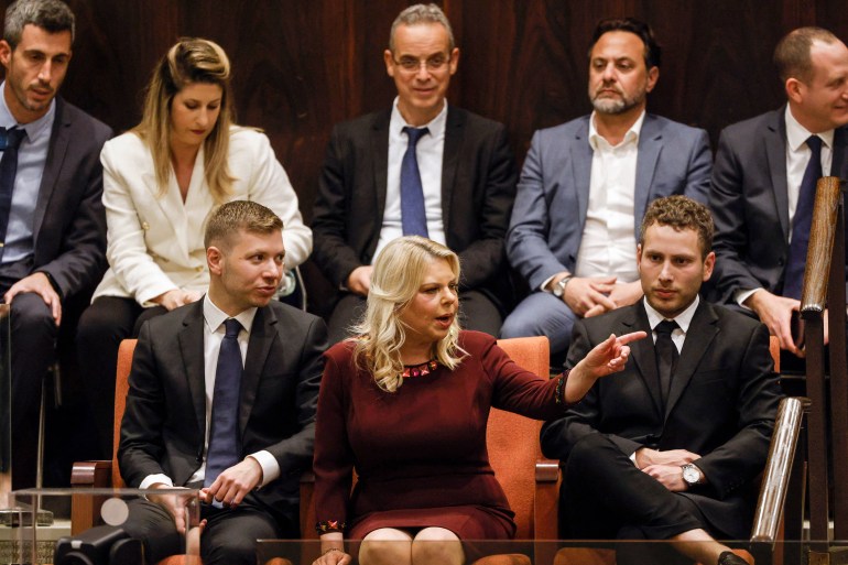 Sara Netanyahu (1st row C), the wife of Israel's Prime Minister Benjamin Netanyahu, sits with their sons Avner and Yair as the country's new government is sworn in at the Knesset (parliament) in Jerusalem, on December 29, 2022. - Netanyahu was sworn in as prime minister after a stint in opposition, heading what analysts call the most right-wing government in the country's history. (Photo by AMIR COHEN / POOL / AFP) (Photo by AMIR COHEN/POOL/AFP via Getty Images)