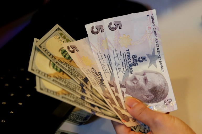 A money changer holds Turkish lira and U.S. dollar banknotes at a currency exchange office in Ankara, Turkey December 16, 2021. REUTERS/Cagla Gurdogan