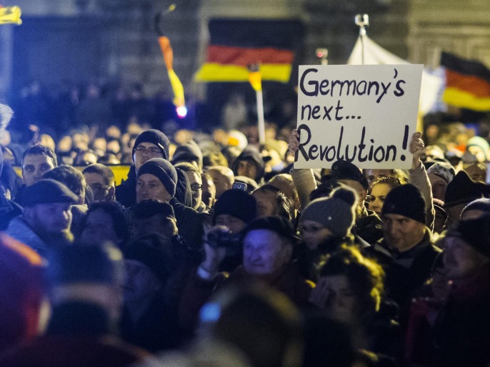 A woman holds a sign during a demonstration organised by anti-immigration group PEGIDA, a German abbreviation for "Patriotic Europeans against the Islamisation of the West", in Dresden December 22, 2014. More than 17,000 people took part in Germany's largest anti-immigrant rally to date on Monday in the eastern city of Dresden, gathering to sing Christmas carols and listen to speakers complain about immigrants and asylum-seekers. REUTERS/Hannibal Hanschke (GERMANY - Tags: CIVIL UNREST POLITICS SOCIETY IMMIGRATION RELIGION)