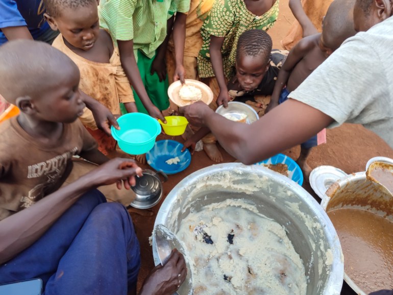 مجموعة من الأطفال السودانيين واليوغندي بالتكية للحصول على الطعام.