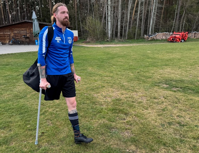Pierre Kaiser, a soccer player on one leg uses two crutches as he arrives for training in Eckental, Germany, April 15, 2025. REUTERS/Louisa Off