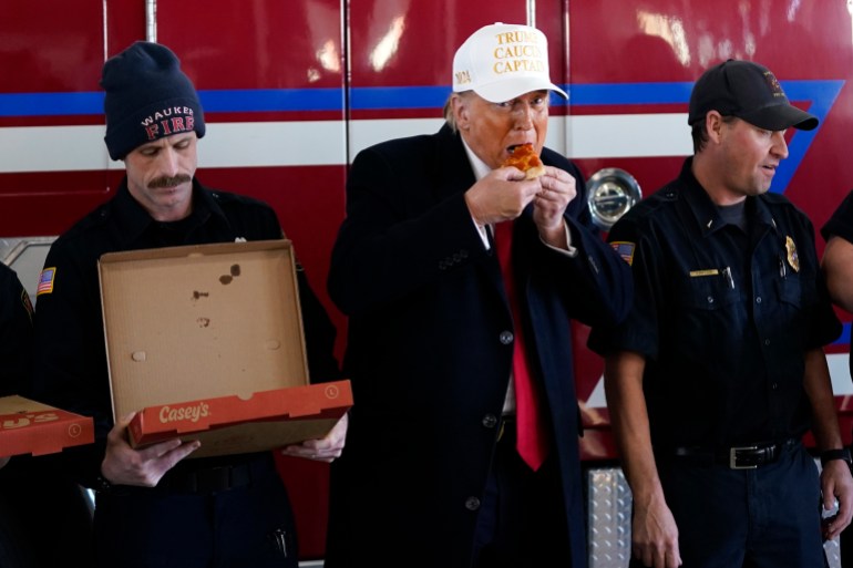 Republican presidential candidate former President Donald Trump eats pizza with fire fighters at Waukee Fire Department in Waukee, Iowa, Sunday, Jan. 14, 2024. (AP Photo/Andrew Harnik)