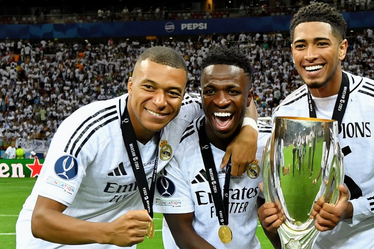WARSAW, POLAND - AUGUST 14: Kylian Mbappe, Vinicius Junior, Jude Bellingham and Rodrygo of Real Madrid pose for a photograph with the UEFA Super Cup Trophy after their team's victory in the UEFA Super Cup 2024 match between Real Madrid and Atalanta BC at National Stadium on August 14, 2024 in Warsaw, Poland. (Photo by Valerio Pennicino - UEFA/UEFA via Getty Images)