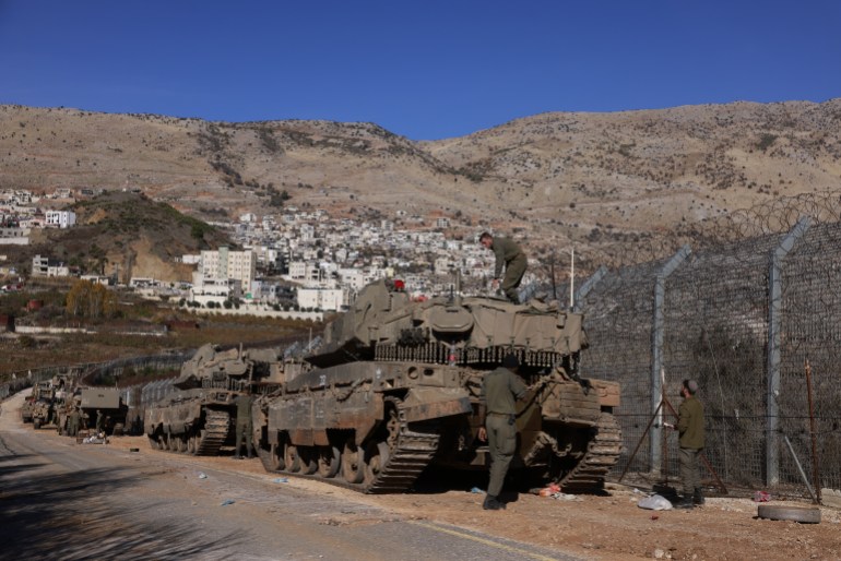 Israeli Army tanks take position on outside the Druze village of Majdal Shams near the buffer zone that separates the Israeli-annexed Golan Heights from the rest of Syria on December 9, 2024. - Israel's Foreign Minister Gideon Saar said on December 9 that his country's military takeover of the buffer zone along its border with Syria was a "limited and temporary step" after Prime Minister Benjamin Netanyahu announced the previous day that he had ordered the army to "take control" of the zone, following the fall of Syrian president Bashar al-Assad. (Photo by Menahem Kahana / AFP)