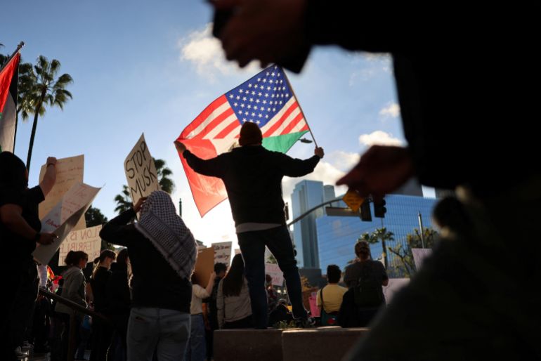 A person holds a flag during a 50501 Movement protest against Project 2025 and the executive orders of U.S. President Donald Trump in Los Angeles, California, U.S. February 5, 2025. REUTERS/David Swanson