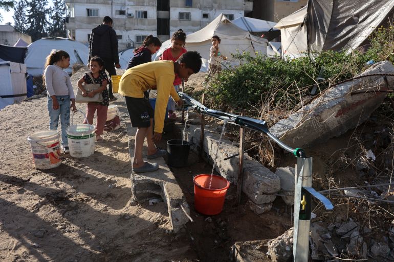 Palestinian children fill containers with water in Gaza City, in the central Gaza Strip on April 26, 2025.