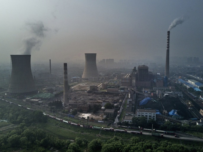 HUAINAN, CHINA - JUNE 16: A Chinese state owned coal fired power plant is seen near a large floating solar farm project under construction by the Sungrow Power Supply Company on a lake caused by a collapsed and flooded coal mine on June 16, 2017 in Huainan, Anhui province, China. The floating solar field, billed as the largest in the world, is built on a part of the collapsed Panji No.1 coal mine that flooded over a decade ago due to over-mining, a common occurence in d