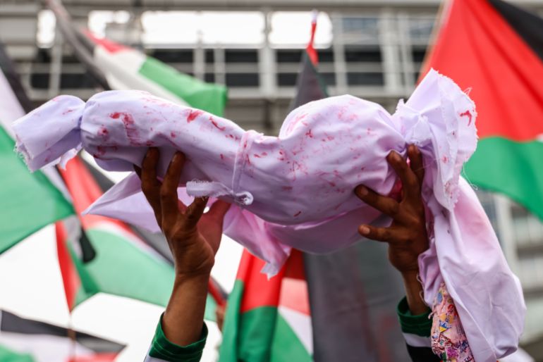 KUALA LUMPUR, MALAYSIA - MARCH 02: A protester holds a cloth imitating a dead baby during a rally on March 02, 2024, in Kuala Lumpur, Malaysia. In solidarity with Palestine amidst reports of over 100 killed and about 750 wounded, a mega rally organized by the Palestine Solidarity Secretariat marched from the Tabung Haji building, passing the United States Embassy, Kuala Lumpur City Centre (KLCC), to Independence (Merdeka) Square before concluding at Padang Merbok, as Israeli forces fired at Palestinians while collecting food aid in the southwest of Gaza City, highlighting the besieged enclave's unprecedented hunger crisis. (Photo by Annice Lyn/Getty Images)