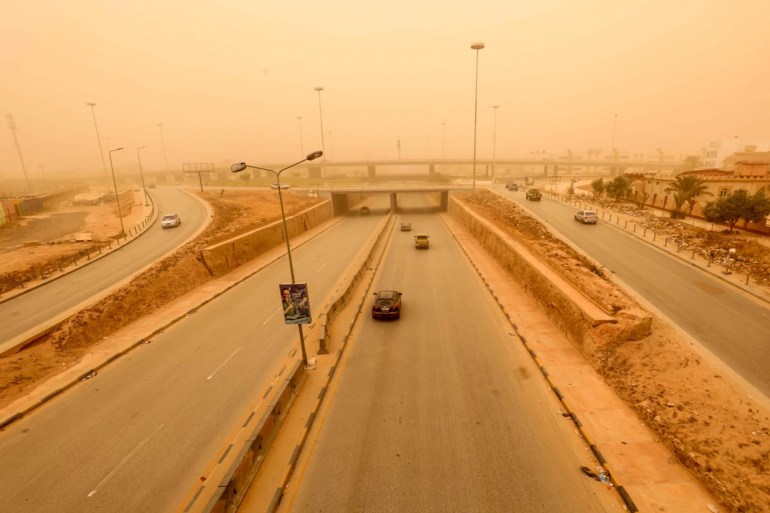 Motorists drive their vehicles through a sandstorm in Libya's eastern city of Benghazi on April 22, 2024. (Photo by Abdullah DOMA / AFP)