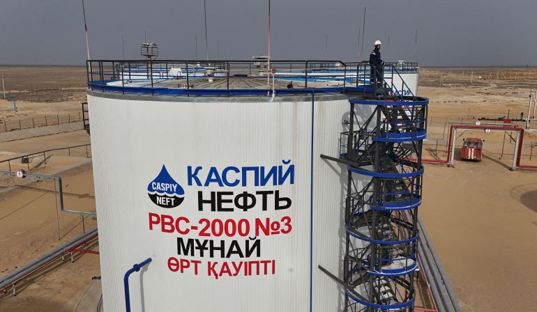 A drone view shows an employee standing on the top of a storage tank at the Airankol oil field operated by Caspiy Neft in the Atyrau Region, Kazakhstan April 1, 2025. REUTERS/Pavel Mikheyev