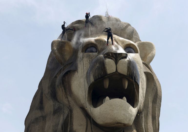 Cleaners spray clean the 37-meter tall tourism icon of the Merlion on the resort island of Sentosa ahead of the city-state's 50th anniversary celebrations in Singapore July 8, 2015. The five day long cleaning is the mythical creature's first "bath" since its last cleaning in 2012. REUTERS/Edgar Su TPX IMAGES OF THE DAY