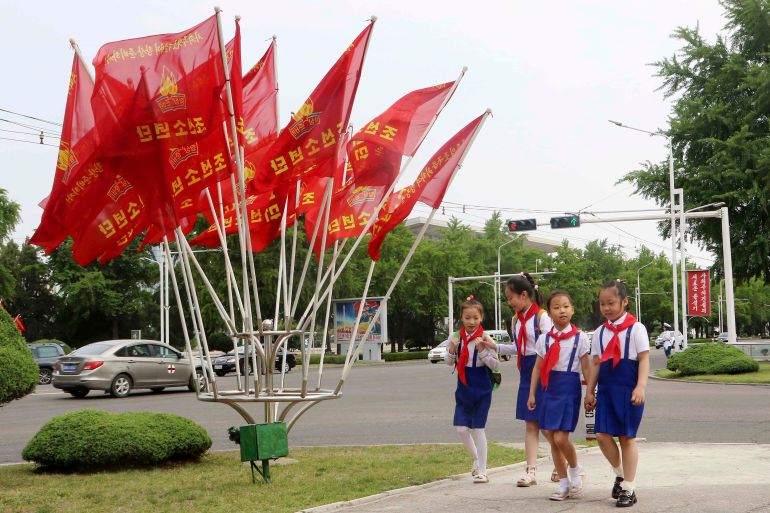 Children walk past the flags, in the street of Pothonggang District, Pyongyang, North Korea Friday, June 6, 2025, the 79th anniversary day of the founding of the Korean Children's Union. (AP Photo/Jon Chol Jin)