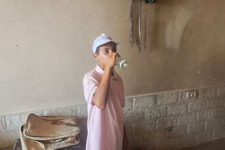 الفتى أمير النصلة يتناول كوبا من الماء والبهارات لسد جوعه الشديد-رائد موسى-غزة-الجزيرة نت