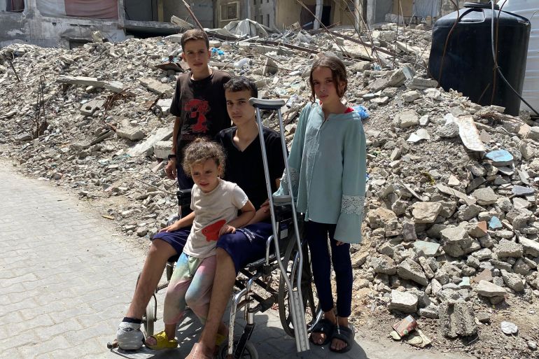 عبيدة عطوان محاطا بأخوته أمام منزلهم المدمر بمدينة دير البلح وسط قطاع غزة-رائد موسى-دير البلح-الجزيرة نت