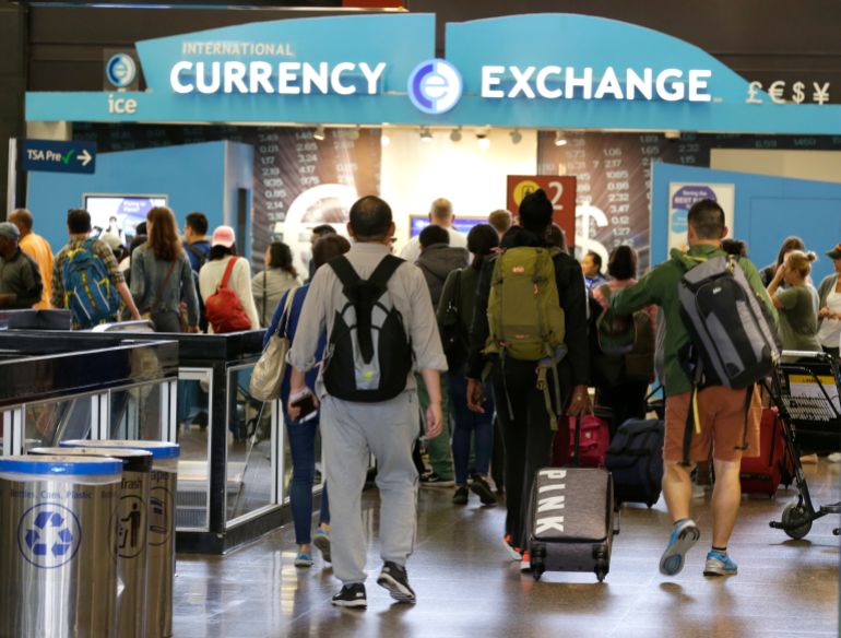 Travelers walk toward a currency exchange at the Seattle-Tacoma International Airport, Monday, June 26, 2017, in Seattle. The U.S. Supreme Court said Monday that President Donald Trump's travel ban on visitors from Iran, Libya, Somalia, Sudan, Syria and Yemen can be enforced if those visitors lack a "credible claim of a bona fide relationship with a person or entity in the United States," and that justices will hear full arguments in October 2017. (AP Photo/Ted S. Warren)