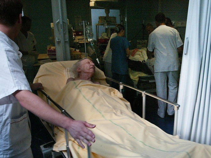 une personne âgée souffrant d'hyperthermie attend des soins, le 13 août 2003 à l'hôpital militaire Bégin à Saint-Mandé. Plusieurs personnes âgées sont décédées ces derniers jours pour des causes liées à la canicule. An elderly man suffering from hyperthermia is tended to by a doctor at the Begin military hospital in Saint-Mandé, Paris, 13 August 2003. A top Parisian physician has claimed that more than a 100 people had died in the intense heat wave that has blanketed France for more than a week. Hospitals across France have been overrun with elderly patients seeking treatment for heat related complaints.