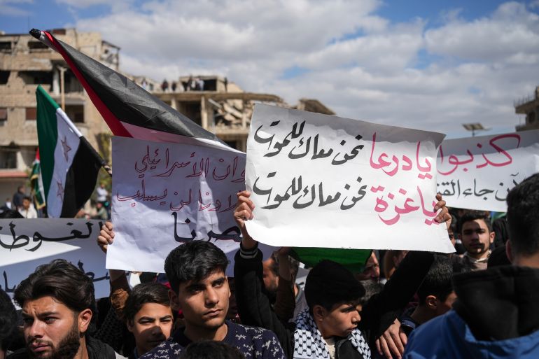 epa12025310 A protester holds a banner reading 'Daraa, we are with you until death. Gaza, we are with you until death' during a demonstration in solidarity with the Palestinian people and against the Israeli occupation and its attacks on Syria, in Harasta near Damascus, Syria, 11 April 2025. EPA-EFE/AHMAD FALLAHA