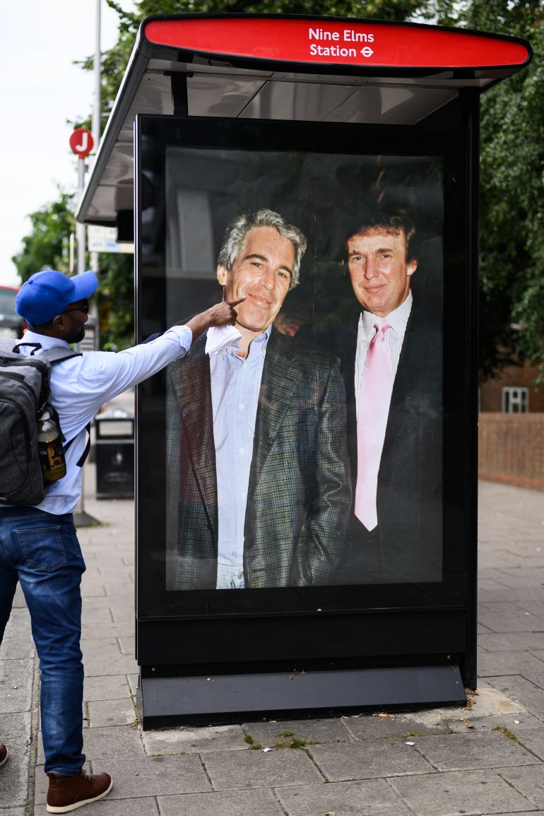 LONDON, ENGLAND - JULY 17: A man gestures to a photograph of US President Donald Trump and convicted child sex offender Jeffrey Epstein after it is unofficially installed in a bus shelter on July 17, 2025 in London, England. The satirical artist behind the stunt has previously targeted Elon Musk and Tesla. The US president is facing criticism from his usually loyal Republican “Make America Great Again” (MAGA) supporters over suggestions that the administration is hiding details of Epstein’s crimes to protect the high profile figures he associated with, which included Trump. Having previously suggested that there was reason to investigate a rumoured list of clients, Trump has now refered to it as a hoax and called those calling for an investigation "weaklings". (Photo by Leon Neal/Getty Images)