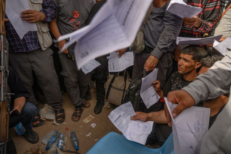 Deported Afghans wait to receive sim cards at the Iranian border on 3 July in Islam Qala. Many arrive hungry and exhausted, having walked for hours in extreme heat. Photograph: Getty Images
