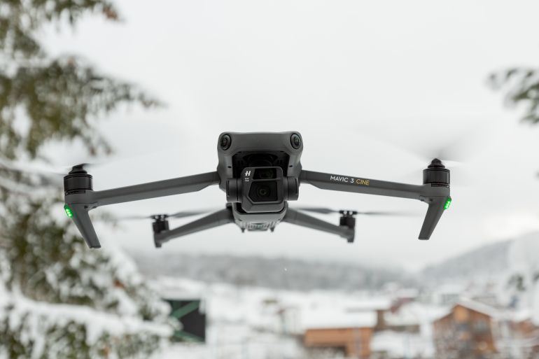 Bakuriani, Georgia - December 12, 2021: Mavic 3 cine, an advanced, foldable consumer drone by DJI is flying against blue sky.