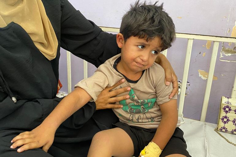 تحتضن منى أبو عريبان طفلها خالد المصاب بحالة مرضية ناجمة عن المجاعة وسوء التغذية الحاد-رائد موسى-دير البلح-الجزيرة نت