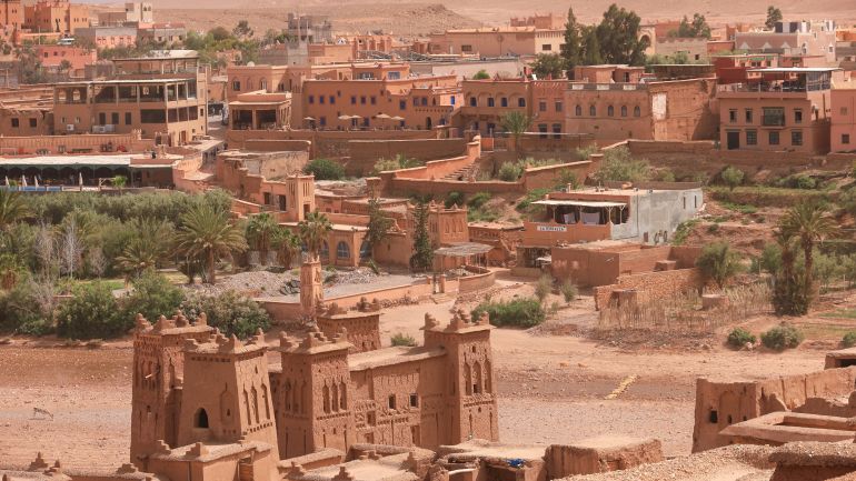 Ouarzazate, Marokkó - 2025. április 29.: Ait Benhaddou világörökségi helyszínének látványos képe teljesen borított piros okkersárga színű.