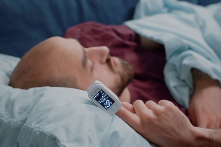 Close up of oximeter on hand of ill person resting فري بيك