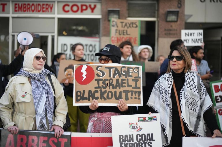 متظاهرات في جوهانسبرغ يرفعن لافتات تطالب بحظر صادرات الفحم إلى إسرائيل وتدعو لقطع إمدادات الطاقة عنها (الجزيرة)
