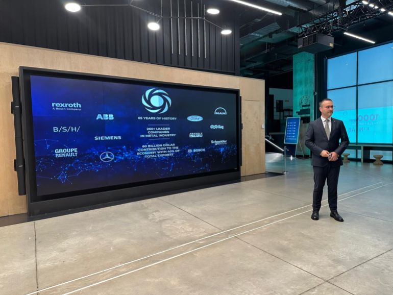 وزير الاقتصاد والصناعة السوري نضال الشعار ونظيره التركي محمد فاتح كاجر يشهدان على اخراج أول عينة إنتاج مشترك (الجزيرة)