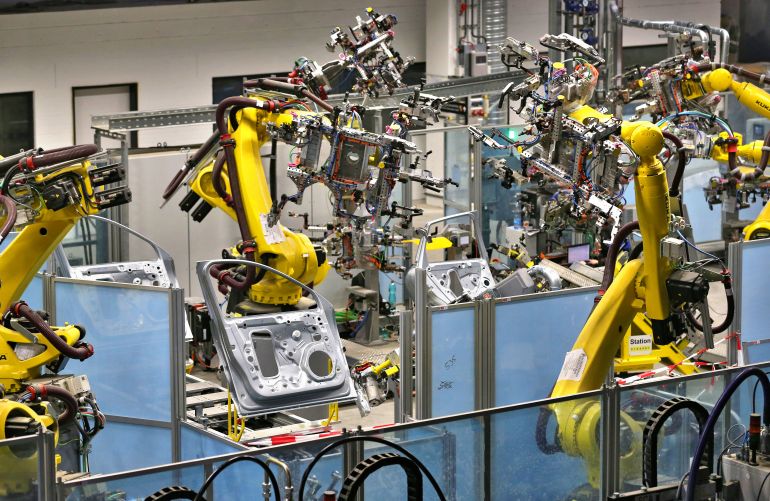 مصنع سيارة بورش - روبوت - ألمانيا View of production robots at the door production line of the new car body manufacture of sports car manufacturer Porsche in Leipzig, Germany, 13 March 2013. The small SUV Macan is planned to become the third Porsche model produced in Leipzig towards the end of the year. In the biggest construction project in Porsche's history the plant in Leipzig is currently being expanded for 500 million euros. Porsche is also currently looking for 1,000 new employees for the enlarged plant. Photo: JAN WOITAS | usage worldwide (Photo by Jan Woitas/picture alliance via Getty Images)
