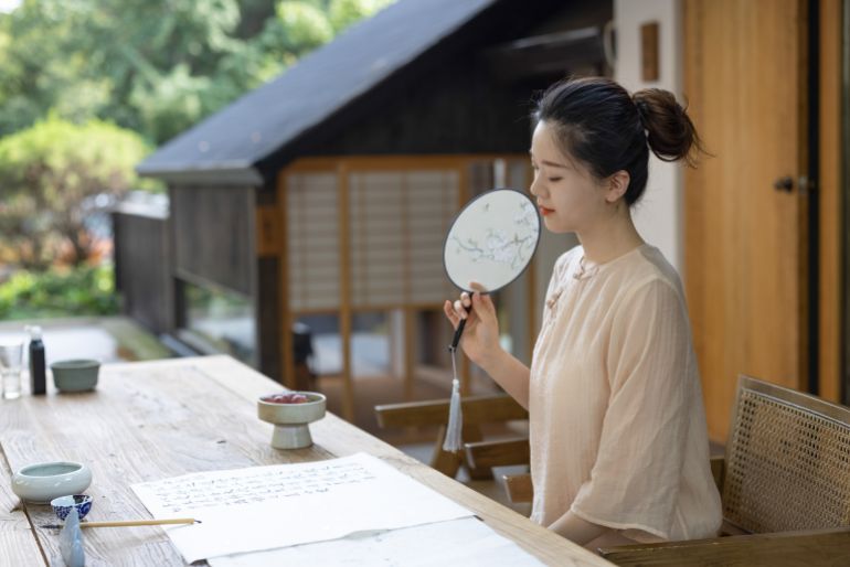Asian women practicing calligraphy