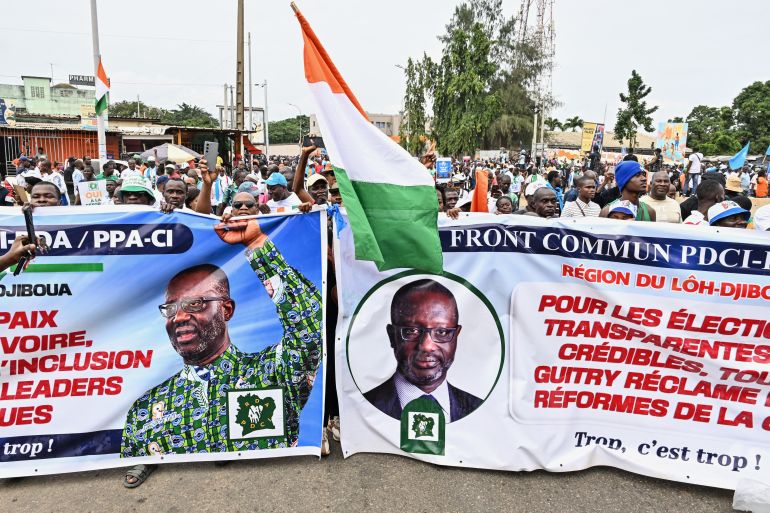 Supporters of different opposition parties wave a flag from Ivory Coast as they carry banners during a march calling for an inclusive election in the neighborhood of Yopougon in Abidjan on August 9, 2025, ahead of the presidential election on October 25, 2025.