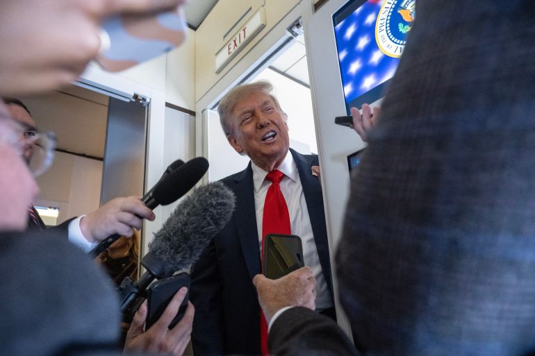 US President Donald Trump speaks to reporters aboard Air Force One in the air on August 15, 2025, en route to Anchorage.