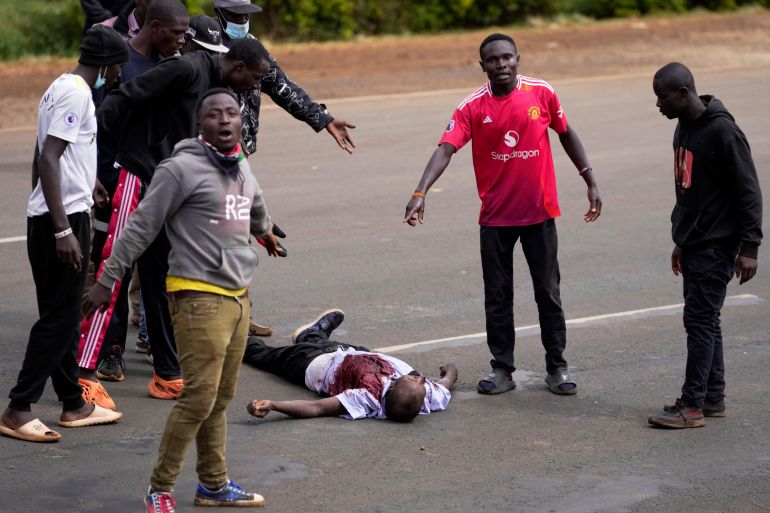 ADDITION: CLARIFIES DATE - Demonstrators gesture next to a man who the crowd claimed had been shot by police, during demonstrations to mark the historic 1990 Saba Saba (a Swahili word that means seven seven) protests for democratic reforms in the Kangemi slum of Nairobi, Kenya, Monday, July 7, 2025. (AP Photo/Brian Inganga)