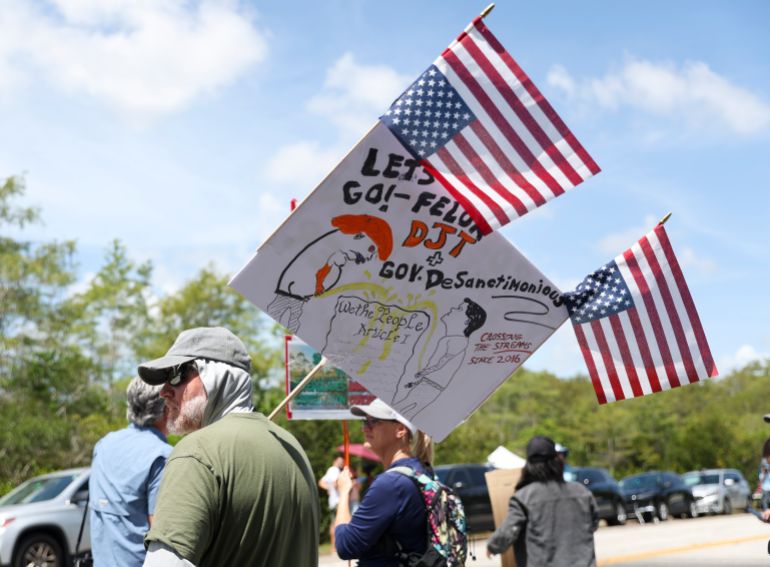 A protester stands outside the migrant detention dubbed "Alligator Alcatraz" at the Dade-Collier Training and Transition Facility, Saturday, July 12, 2025, in Ochopee, Fla. (AP Photo/Alexandra Rodriguez)