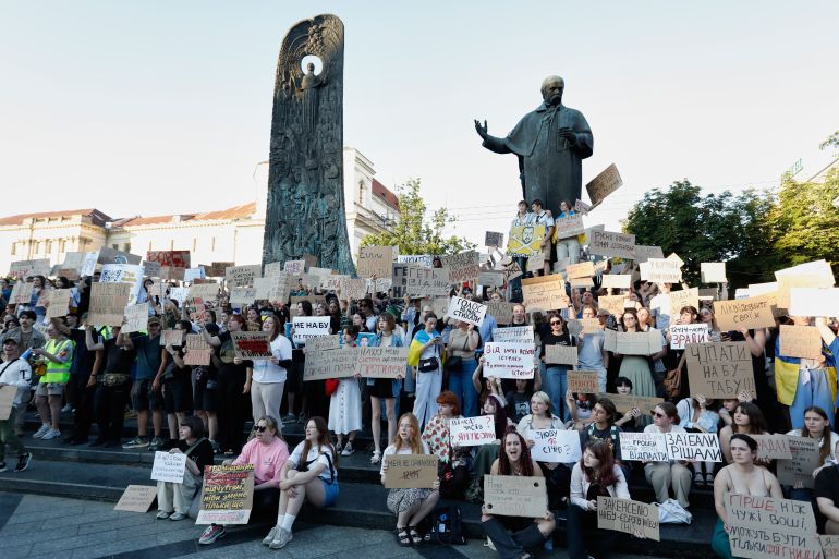 Demonstrators hold sign during a protest against a law that targets anti-corruption institutions in Lviv, Ukraine, Wednesday, July 23, 2025. (AP Photo/Mykola Tys)