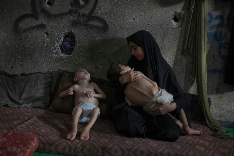 Samah Matar poses for a photo with her sons Yousef, 6, in her arms, and Amir, 4, who suffer from malnutrition and cerebral palsy, at a U.N.-run school in Gaza City, Saturday, July 26, 2025. In Gaza, malnutrition is often worsened by preexisting conditions and compounded by illnesses linked to inadequate health care and poor sanitation, largely the result of the ongoing war. (AP Photo/Jehad Alshrafi)