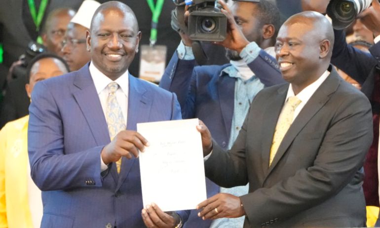 William Ruto, and his deputy Rigathi Gachagwa, show the certificate after the announcement in the presidential race at the Centre in Bomas, Nairobi, Kenya, Monday, Aug.15, 2022.. Kenya's election commission announced Monday that William Ruto, has won with 50.49 percent of the vote, and called the vote "credible, fair and peaceful",. (AP Photo/ Sayyid Abdul Azim)