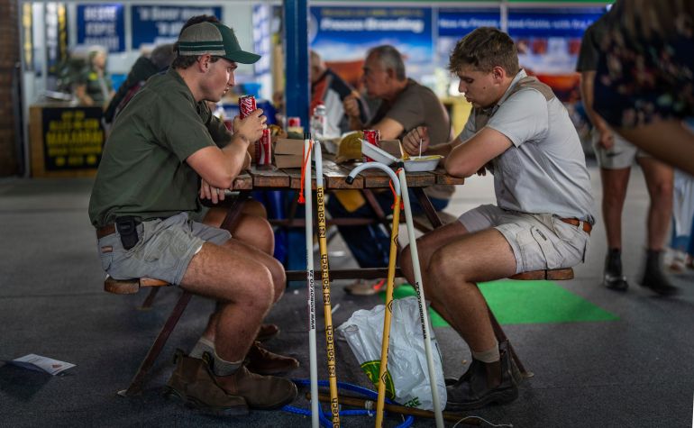 Farmers sit for lunch at the Nampo agricultural fair, one of the largest in the southern hemisphere, near Bothaville, South Africa, May 15, 2025. (AP Photo/Jerome Delay)