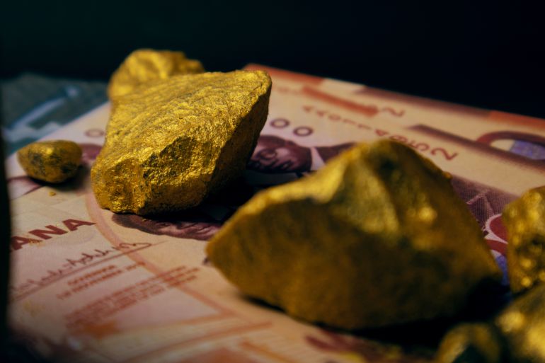 Ghanaian cedi notes and Lump of Gold on dark background. Raw metal ore, galamsey, minning, wealthy, rich, precious mineral