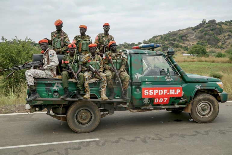 South Sudanese military police officers sit on a pickup truck as they monitor the area during a South Sudanese Unified Forces deployment ceremony at the Luri Military Training Centre in Juba on November 15, 2023. Hundreds of former rebels and government troops in South Sudan's Unified Forces were deployed at a long-overdue ceremony on November 15, 2023, marking progress for the country's lumbering peace process. (Photo by Peter Louis GUME / AFP)