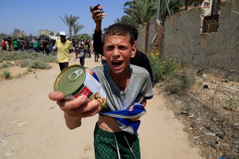 A Palestinian youth holds a can of chickpeas from an aid package dropped from an airplane, amid a hunger crisis, in Zawayda, in the central Gaza Strip, July 28, 2025. REUTERS/Hatem Khaled