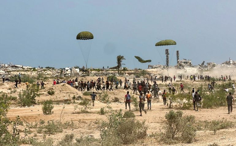 People scramble to collect parachuted aid supplies, at the site where Palestinian boy Muhannad Eid died after he was struck by a box of airdropped aid, in the central Gaza Strip August 9, 2025. REUTERS/Stringer TPX IMAGES OF THE DAY