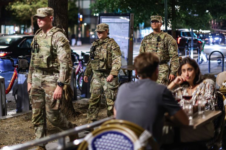 Members of the Ohio National Guard patrol near diners on 14th Street in Washington, DC, US, on Saturday, Aug. 23, 2025. National Guard troops deployed to Washington, DC, will now carry weapons, the Pentagon said, signaling a more aggressive posture after President Donald Trump warned he's "not playing games" with the federal takeover of the city's law enforcement. Photographer: Valerie Plesch/Bloomberg via Getty Images