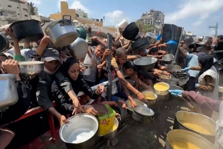PALESTINIANS GATHERING AT A SOUP KITCHEN IN GAZA CITY TO GET FOOD / PALESTINIAN MOTHER OF THREE, HEBA AL-GHAMARI, TALKING ABOUT DAILY STRUGGLE TO GET FOOD