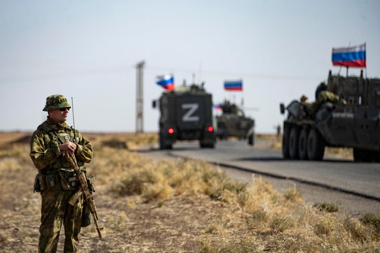 Soldiers of a Russian military convoy and their US counterparts exchange greetings as their patrol routes intersect in an oil field near Syria's al-Qahtaniyah town in the northeastern Hasakah province, close to the border with Turkey, on October 8, 2022. (Photo by Delil SOULEIMAN / AFP)